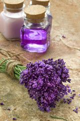 Obraz na płótnie Canvas Bukiet świeżych purpurowe kwiaty i butelki z mydłem i balsam