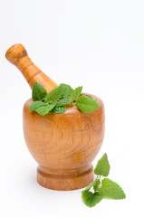wooden mortar with melissa leaves