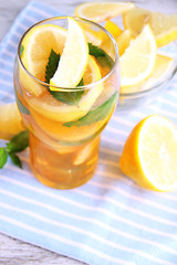 Iced tea with lemon and mint on wooden table