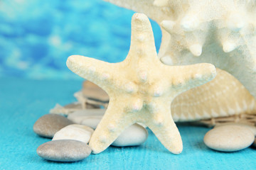 White starfishes on blue wooden table on sea background