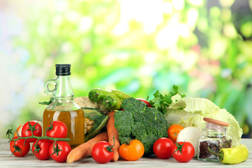 Fresh vegetables in basket on wooden table on natural