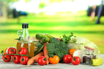 Fresh vegetables in basket on wooden table on natural
