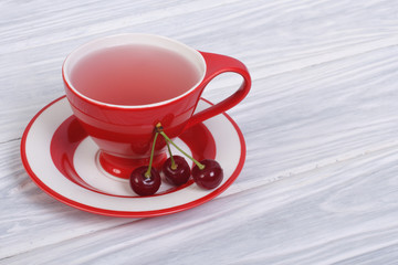 Fruit tea with berries cherries in a red cup