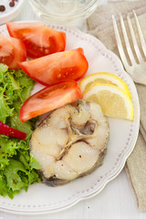 boiled fish with tomato, lettuce and lemon