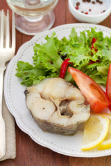 boiled fish with vegetables on the plate