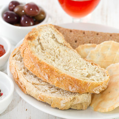 bread on the plate with olives and wine