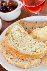 bread with olives and glass of pink wine