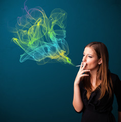 Fototapeta premium Pretty lady smoking cigarette with colorful smoke