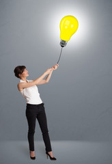 Pretty lady holding a light bulb balloon