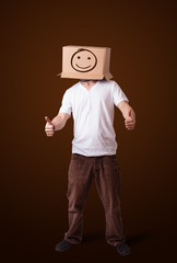 Young man gesturing with a cardboard box on his head with smiley