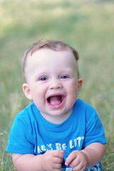portrait of  laughing baby boy age of 9 months outdoors