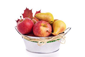 Apples and pears in metal bucket with autumn leaf