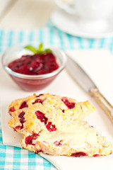 Scone with orange zest and berries with butter