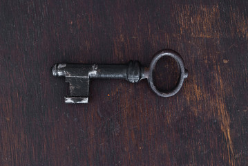 Old key on dark wooden background