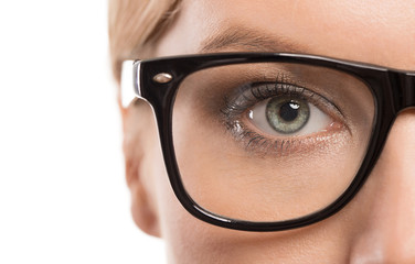 Close up of female eye with glasses isolated on white background