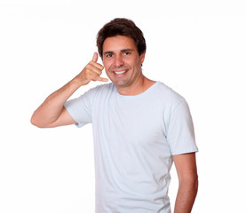 Smiling guy gesturing call me with one hand