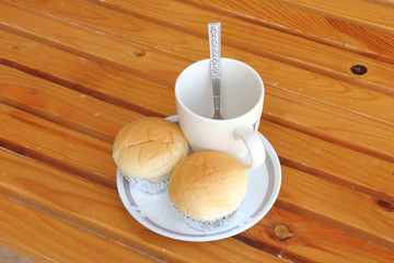 Bread with empty cup of coffee on the yellow wood table