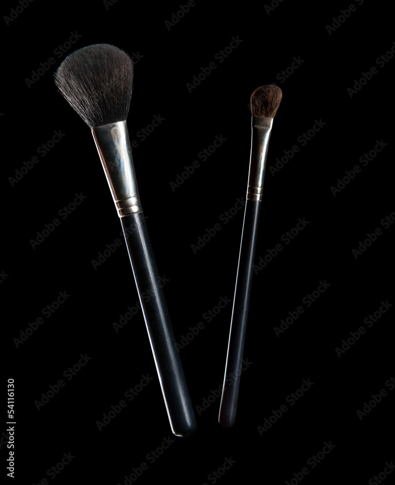 Wall mural Make-up brushes isolated on black background