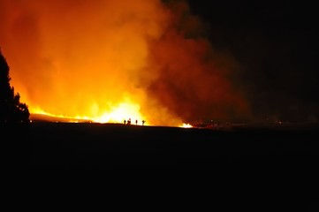 Fototapeta na wymiar Fire-fighters on a night time blaze in the Drakensberg, 