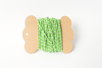 Green yarn thread roll on paper