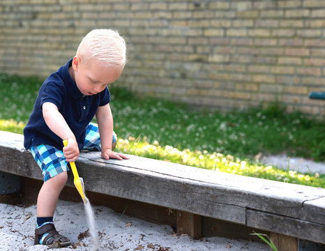 Little boy playing in a sand pit