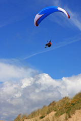 paraglider over sand dunes