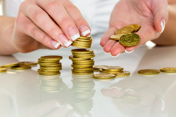 Frau mit Münzstapel beim Geld sparen