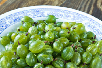 Green gooseberries on white plate