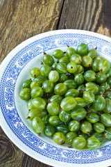Green gooseberries on white plate