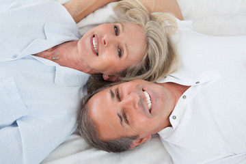 Happy Couple Lying On Bed