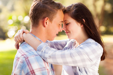 young teenage couple hugging with eyes closed