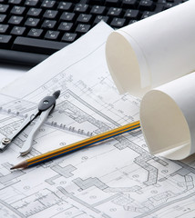 Pencil, dividers and blueprint on a laptop