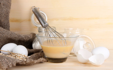 Ingredients for dough on wooden table on wooden background