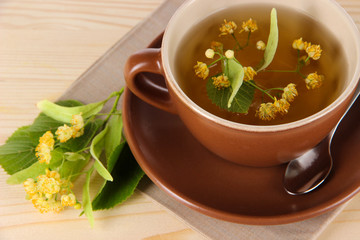 Cup of tea with linden on napkin   wooden table