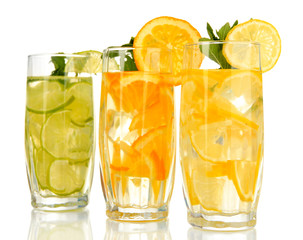 Glasses of fruit drinks with ice cubes isolated on white