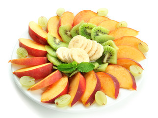 Assortment of sliced fruits on plate, isolated on white