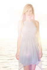 Fototapeta na wymiar Beautiful Woman Wearing Casual Dress Standing Against Sea In Bac