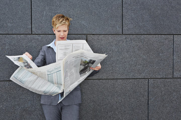 Frau liest Zeitung an bei Wind und Wetter