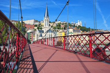 red footbridge on Saone river and church