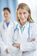 Fototapeta premium Happy Female Doctor Standing Arms Crossed At Clinic