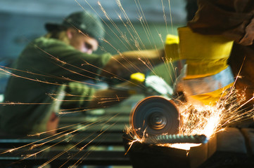 Worker making sparks while welding steel - obrazy, fototapety, plakaty