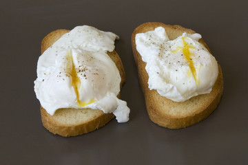 Classic breakfast - poached eggs on toast on a brown plate
