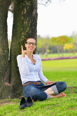 Beautiful young woman with  tablet in park