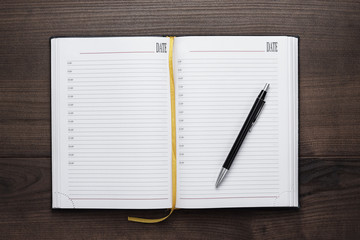 opened notebook and pen on wooden table