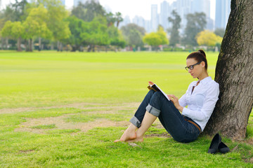 Young woman reading a book in the park