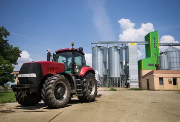 Fotobehang tractor in front of silos © Budimir Jevtic