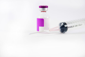 Purple label ampule and disposable syringe on white background