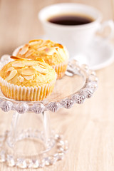 Almond muffins on cake stand with a cup of coffee