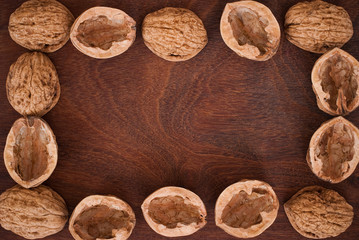 frame of walnuts on wooden background