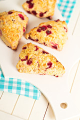 Scones with orange zest and berries on a cutting board
